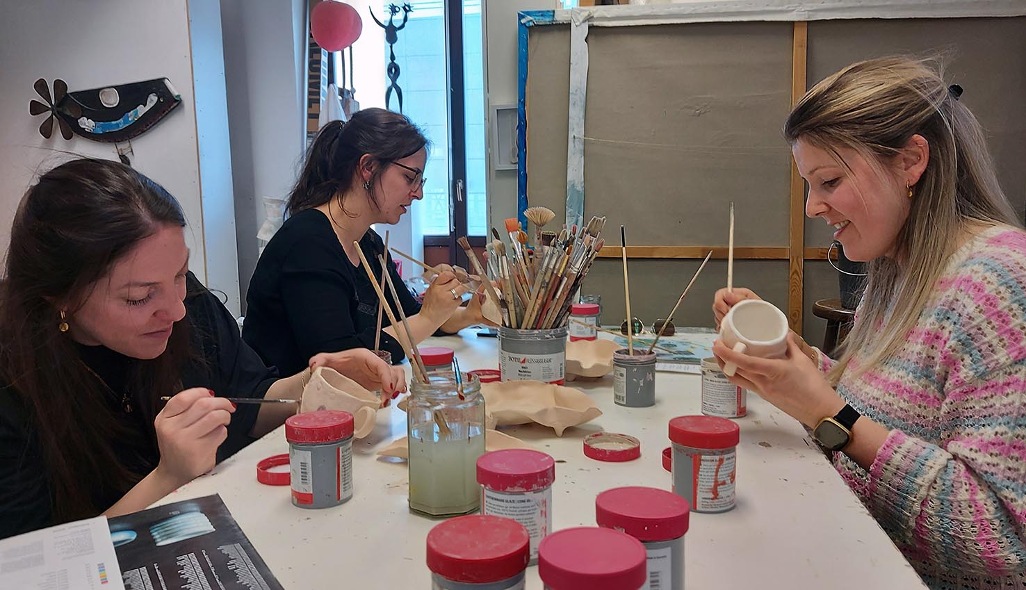 Teilnehmerinnen bemalen getöpferte Tassen im Keramik-Workshop im MainKreativRaum
